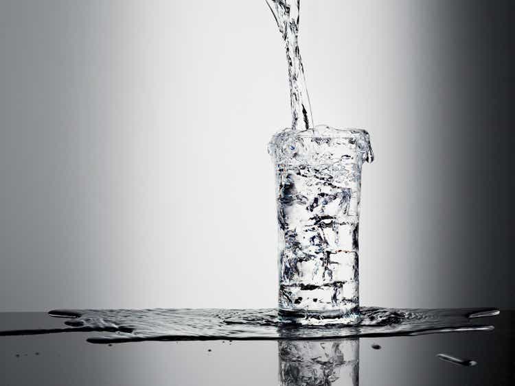 Water pouring into the bottle and overflowing