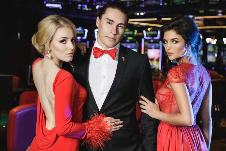 Seguros de hombre y dos mujeres hermosas en el casino
