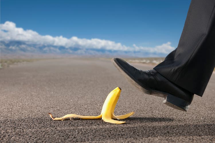 Businessman about to step on banana peel