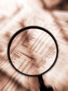 Magnifying glass examining stock pages