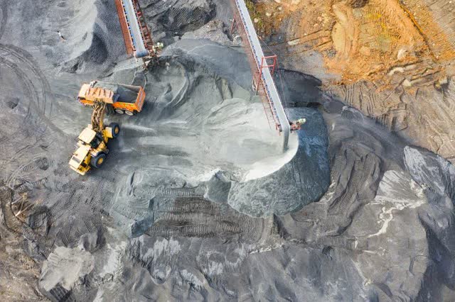 A Yellow excavator truck being loaded at an open pit coal mine.