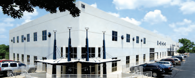 A white building with cars parked in front of it Description automatically generated with medium confidence