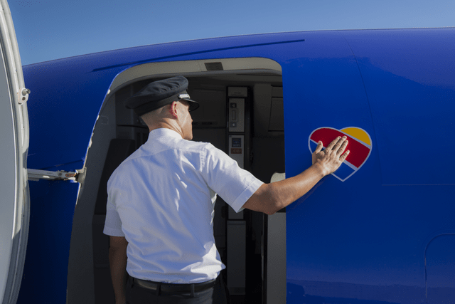 This image shows a Southwest Airlines pilot entering an airplane.