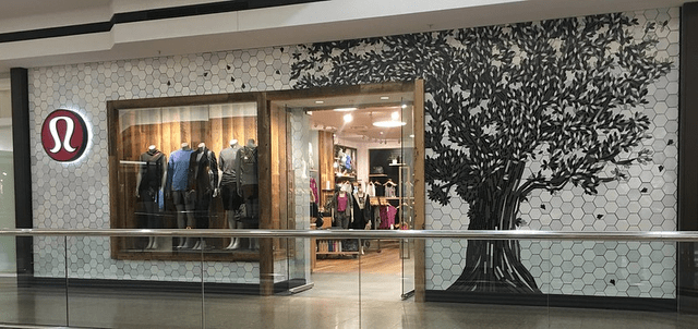 A store front with a tree mural on the wall Description automatically generated