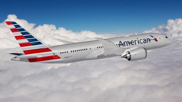 This image shows a Boeing 787 airplane in American Airlines colors with clouds in the background.